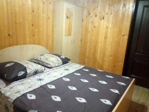 a bedroom with a bed with a black and white comforter at Сонячний in Slavske