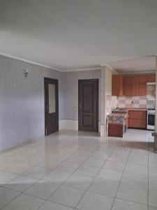 a large kitchen with brown cabinets and a white tile floor at Сонячний in Slavske