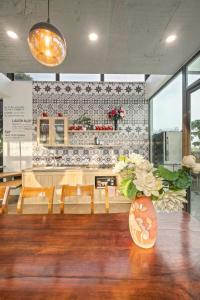 a dining room with a table with a vase of flowers at Greenfield Ba Vì - Nắng Villa in Yên Bài