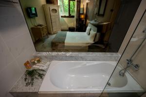 a reflection of a bathroom with a tub in a mirror at Villa VICTORIA Loven Park Boutique Rooms Sofia in Sofia