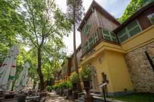 a building with tables and umbrellas in front of it at Villa VICTORIA Loven Park Boutique Rooms Sofia in Sofia