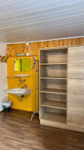 a bathroom with a sink and a yellow wall at SKILL Mountain Lodge - Ski und Bike Hostel im Sommer mit JOKER CARD in Saalbach-Hinterglemm