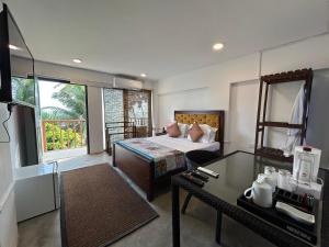 a hotel room with a bed and a desk and a room at Lavanga Express in Hikkaduwa
