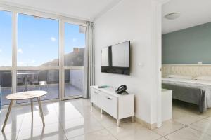 a bedroom with a bed and a table and a tv at Mariposa del Sol in Patalavaca +58 photos