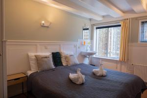 two ducks sitting on a bed in a bedroom at 't Lytse Knipke in Lemmer