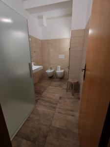a bathroom with two toilets and a sink and a door at Hotel Ristorante Gusana in Gavoi +26 photos