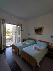 two beds in a room with a balcony at Hotel Ristorante Gusana in Gavoi