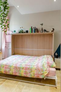 a bed with a wooden head board in a room at My cocoon in Vaison in Vaison-la-Romaine