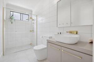 a white bathroom with a sink and a toilet at Snowy Lake Haven in Jindabyne +11 photos