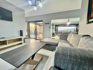 a living room with a couch and a table at Athule Inn - Cradle in Hekpoort