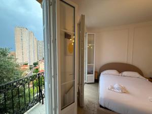 a bedroom with a bed and a balcony at Frontière de Monaco - Spacieux et confortable - GM in Beausoleil