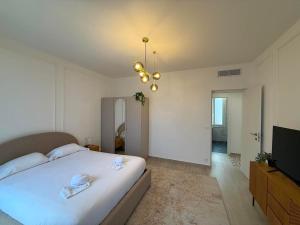 a bedroom with a large white bed and a television at Frontière de Monaco - Spacieux et confortable - GM in Beausoleil