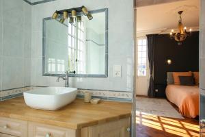a bathroom with a sink and a bed at Quatorze - manoir au coeur du parc du Château de La Garnache in La Garnache +20 photos