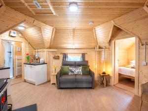 a living room with a couch in a tiny house at Chalet Oak Bothy by Interhome in Coldstone