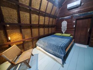 a room with a bed and two chairs in it at Pondok Kebun Jati in Pawenang
