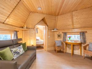 a living room with a couch and a table in a cabin at Chalet Oak Bothy by Interhome in Coldstone