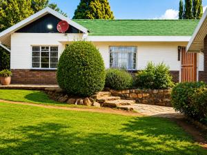 a house with a stone retaining wall in the yard at The Big Five Bed and breakfast in Mooiriver