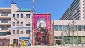 a tall building with a colorful mural on the side of it at NEXTRAVELER iNN in Osaka