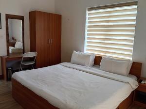 a bedroom with a bed and a desk and a window at NIRVANA HAVEN HOME STAY in Trivandrum