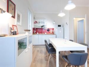 a white kitchen with a white table and chairs at Apartment Bacolla by Interhome in Cocconato