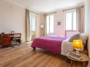 a bedroom with a bed and a desk and a table with a lamp at Apartment Bacolla by Interhome in Cocconato