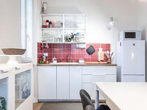 a kitchen with white cabinets and a white refrigerator at Apartment Bacolla by Interhome in Cocconato