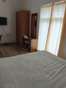 a bedroom with a bed and a desk and a window at NIRVANA HAVEN HOME STAY in Trivandrum