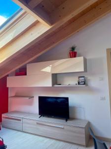 a living room with a flat screen tv on a wall at ValtellinaSuite in Villa di Tirano