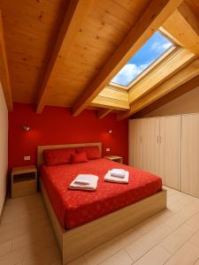a bedroom with a large red bed with a skylight at ValtellinaSuite in Villa di Tirano