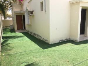 a yard with green grass next to a building at Masirah oyster in Ḩilf