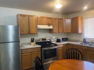 a kitchen with wooden cabinets and a stainless steel refrigerator at Cozy Anchorage retreat in Anchorage