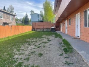 a yard next to a house with a fence at Cozy Anchorage retreat in Anchorage