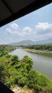 a view of a river with trees in the foreground at Peacock residency in Edavanna