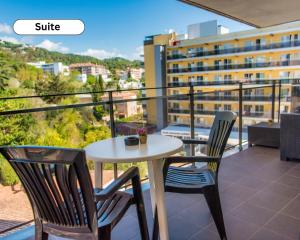 a table and chairs on a balcony with a view of a building at Hotel Acacias Suites & Spa in Lloret de Mar