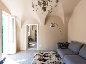 a living room with a couch and a chandelier at Apartment Nella Piazza by Interhome in Airole