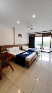 two beds in a room with a balcony at Peacock residency in Edavanna