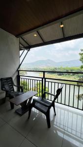 a balcony with two chairs and a table and a view at Peacock residency in Edavanna