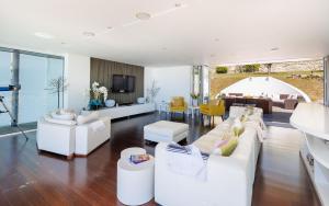 a living room with white furniture and a dining room at Kittiwake - Ventnor Bay with Hot Tub in Ventnor