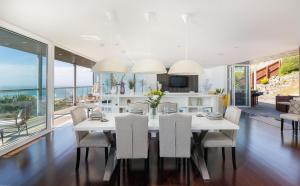 a dining room with a white table and chairs at Kittiwake - Ventnor Bay with Hot Tub in Ventnor