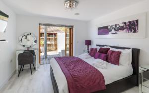 a bedroom with a bed with purple blankets and a chair at Kittiwake - Ventnor Bay with Hot Tub in Ventnor