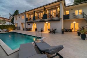 a villa with a swimming pool and a house at CURICTA Design Apartments in Krk