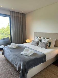 a bedroom with a large bed with towels on it at Authentic Charm C2 in Troia