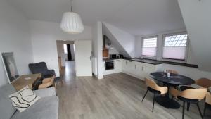 a living room with a couch and a table and chairs at Der Stader Fernblick in Stade +3 photos
