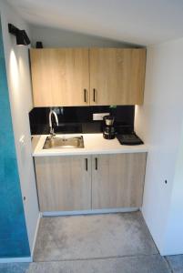 a small kitchen with wooden cabinets and a sink at Sofita Rooms in Nafplio