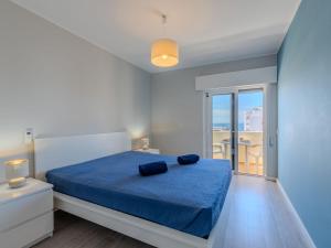 a bedroom with a bed with blue sheets and a window at Apartment Mirasol by Interhome in Praia da Rocha