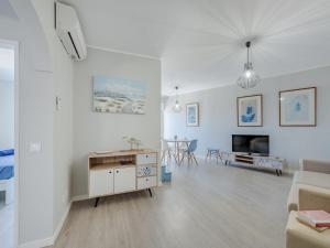 a white living room with a couch and a tv at Apartment Mirasol by Interhome in Praia da Rocha