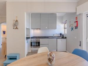 a kitchen with white cabinets and a wooden table at Apartment Mirasol by Interhome in Praia da Rocha
