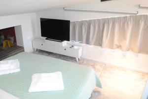 a bedroom with a bed and a flat screen tv at Sofita Rooms in Nafplio