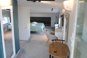 a room with a bed and a chair and a table at Sofita Rooms in Nafplio