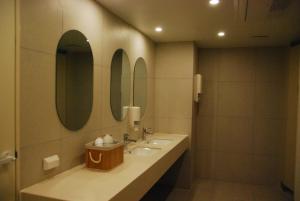 a bathroom with two sinks and two mirrors at 굿데이 큐브 캡슐 호텔 in Busan +40 photos